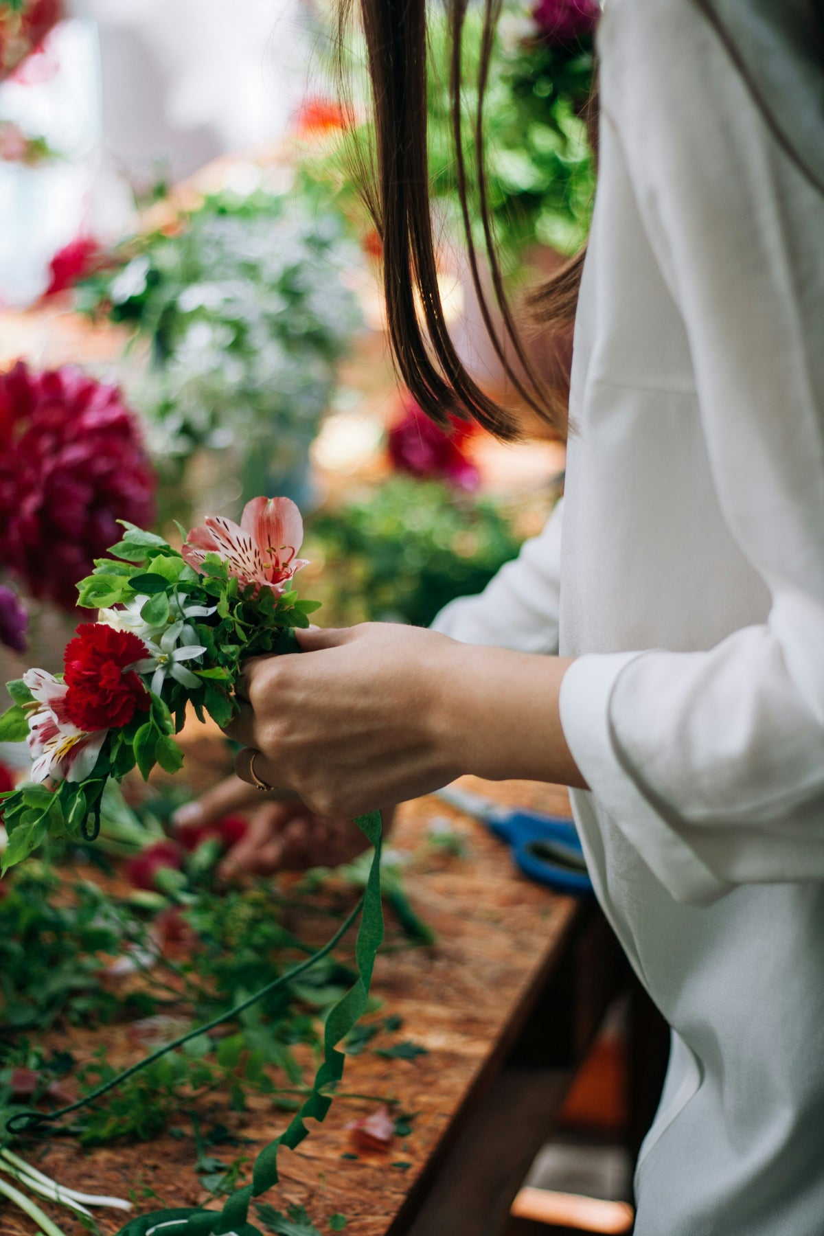 Florist arranging fresh flowers at a worktable